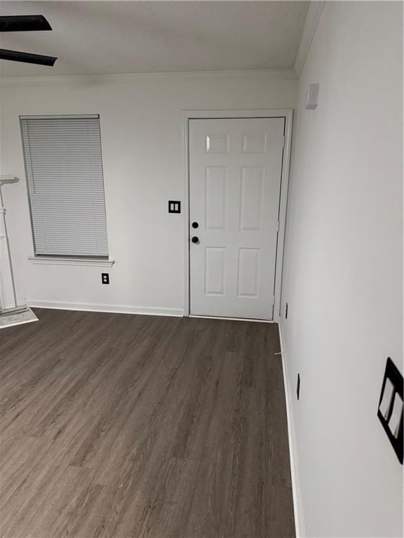 interior space with baseboards, ornamental molding, and dark wood-style flooring