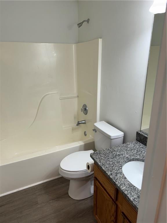 bathroom featuring vanity, shower / bathing tub combination, toilet, and wood finished floors