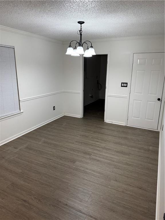 unfurnished dining area with crown molding, a textured ceiling, a notable chandelier, and dark wood finished floors