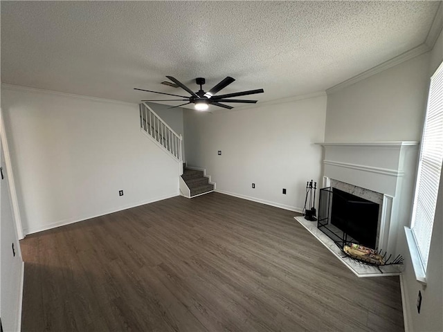 unfurnished living room featuring crown molding, ceiling fan, dark wood-style floors, and a textured ceiling