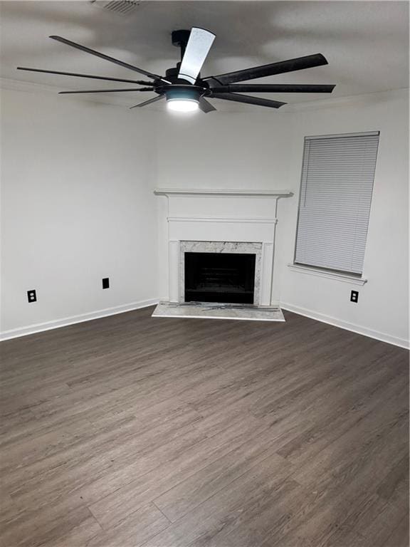 unfurnished living room featuring ceiling fan, wood finished floors, and a fireplace