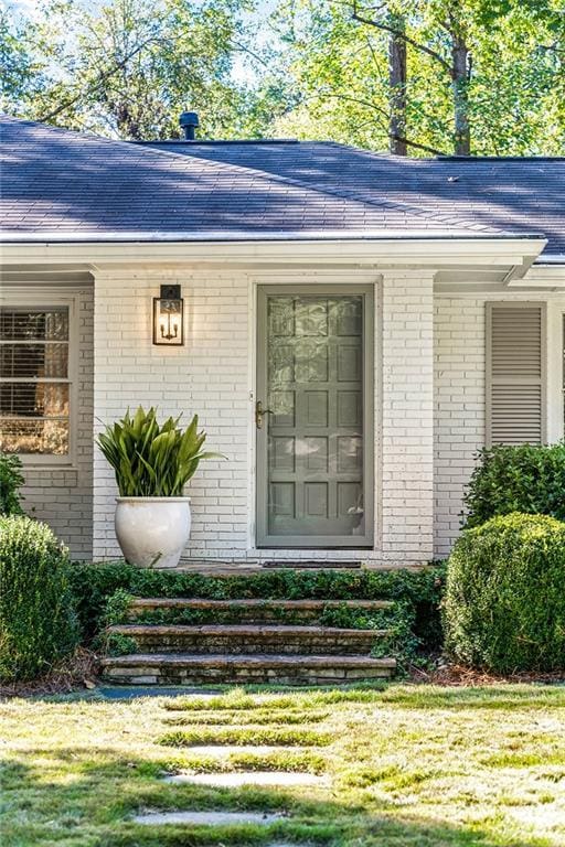 doorway to property with a lawn