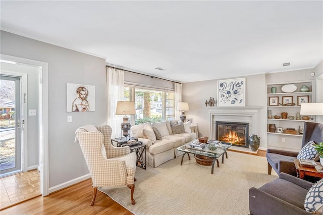 living room featuring built in features and light hardwood / wood-style flooring