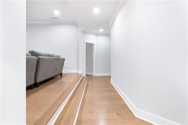 hall with ornamental molding and light hardwood / wood-style flooring