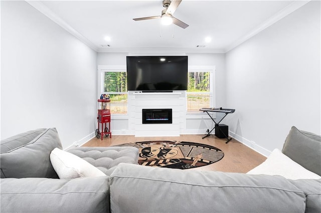 living room with ornamental molding, ceiling fan, and light wood-type flooring