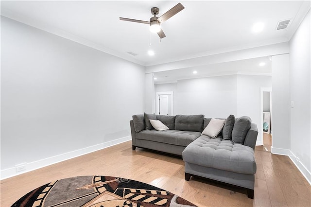 living room featuring ceiling fan, light hardwood / wood-style floors, and crown molding