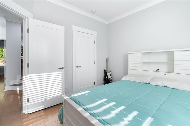 bedroom featuring multiple windows, ornamental molding, and hardwood / wood-style flooring