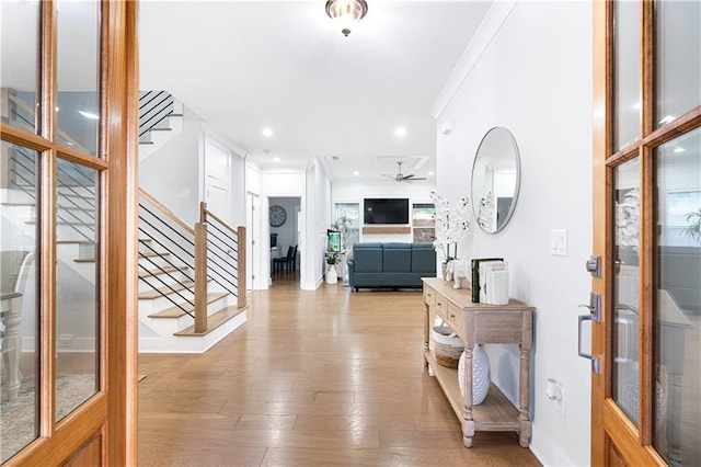 foyer entrance with ceiling fan, light hardwood / wood-style floors, french doors, and ornamental molding