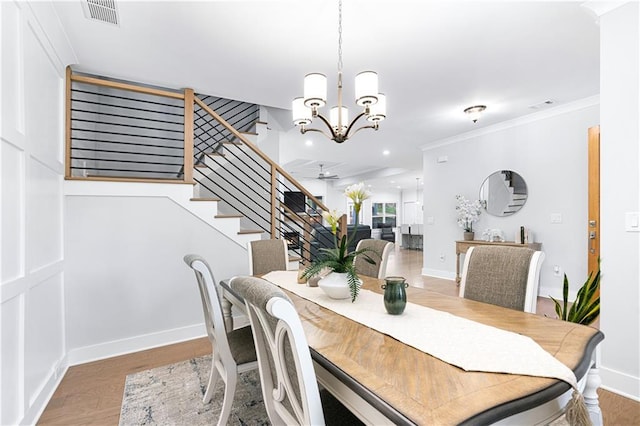 dining space with ceiling fan with notable chandelier, crown molding, and wood-type flooring