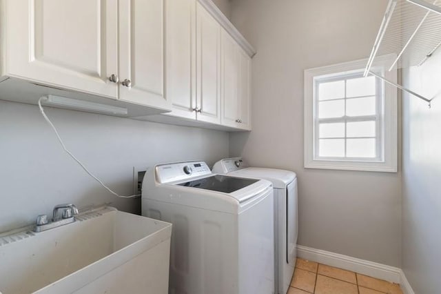 laundry room with light tile patterned floors, sink, separate washer and dryer, and cabinets