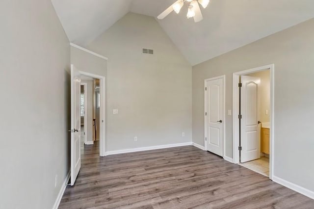 unfurnished bedroom featuring light hardwood / wood-style floors, ensuite bath, high vaulted ceiling, and ceiling fan