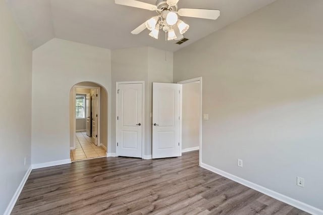 empty room featuring ceiling fan, high vaulted ceiling, and light hardwood / wood-style flooring