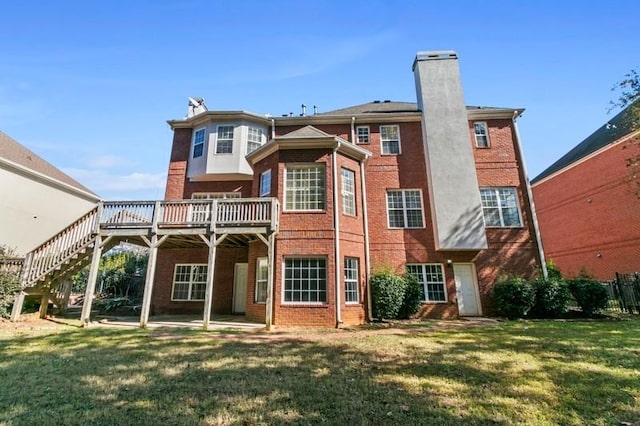 back of property featuring a wooden deck and a yard