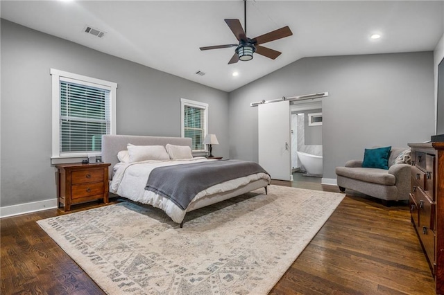 bedroom with lofted ceiling, dark wood-type flooring, ceiling fan, ensuite bathroom, and a barn door