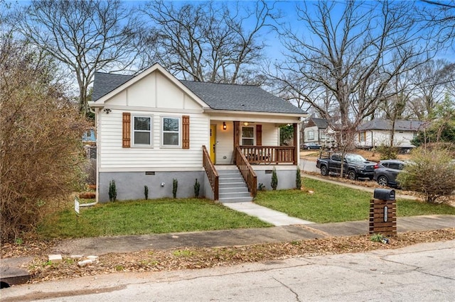 bungalow with covered porch and a front yard