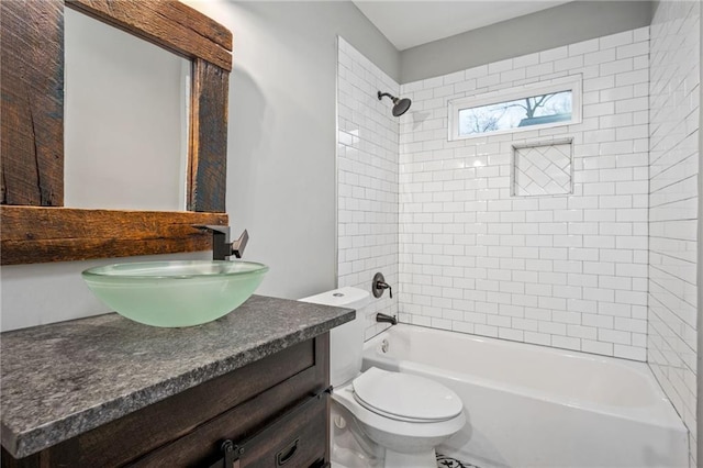 full bathroom featuring tiled shower / bath combo, vanity, and toilet