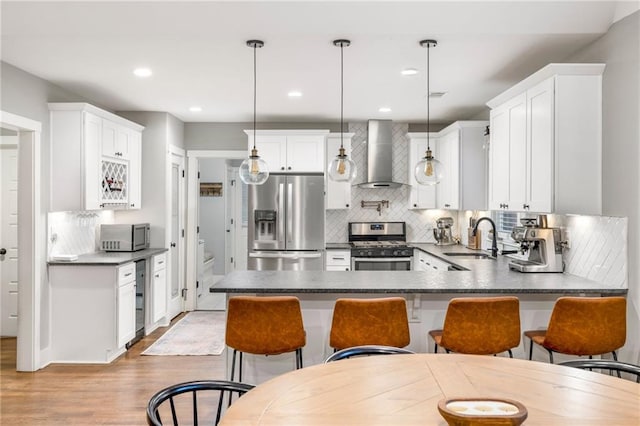 1375 Miller Reed Ave SE, Atlanta, GA 30315 - kitchen featuring wall chimney range hood, decorative backsplash, appliances with stainless steel finishes, dark countertops, and a sink