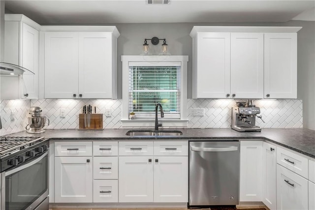 1375 Miller Reed Ave SE, Atlanta, GA 30315 - kitchen with wall chimney exhaust hood, white cabinets, tasteful backsplash, a sink, and appliances with stainless steel finishes