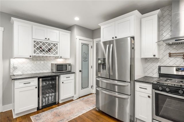 1375 Miller Reed Ave SE, Atlanta, GA 30315 - kitchen featuring wine cooler, wall chimney range hood, white cabinets, backsplash, and stainless steel appliances
