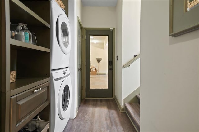 clothes washing area with stacked washing maching and dryer, cabinets, and dark hardwood / wood-style floors