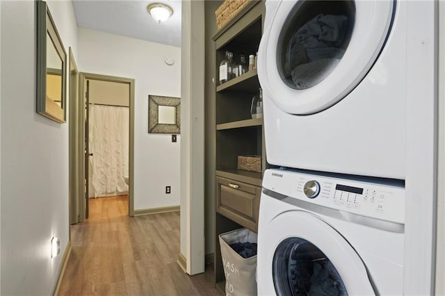 washroom featuring dark hardwood / wood-style flooring and stacked washer / drying machine