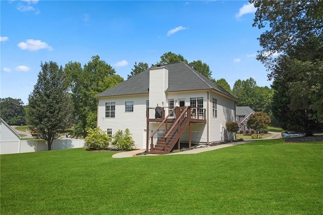 back of house featuring a lawn and a deck