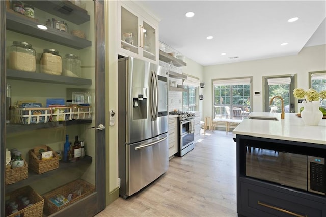 kitchen with stainless steel appliances, light hardwood / wood-style floors, and sink