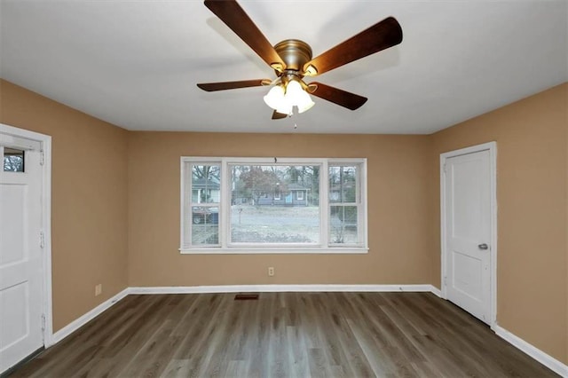 empty room featuring ceiling fan and dark hardwood / wood-style flooring