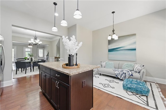 2828 Broughton Ln SE, Atlanta, GA 30339 - kitchen featuring a chandelier, hardwood / wood-style flooring, ornamental molding, a center island, and hanging light fixtures