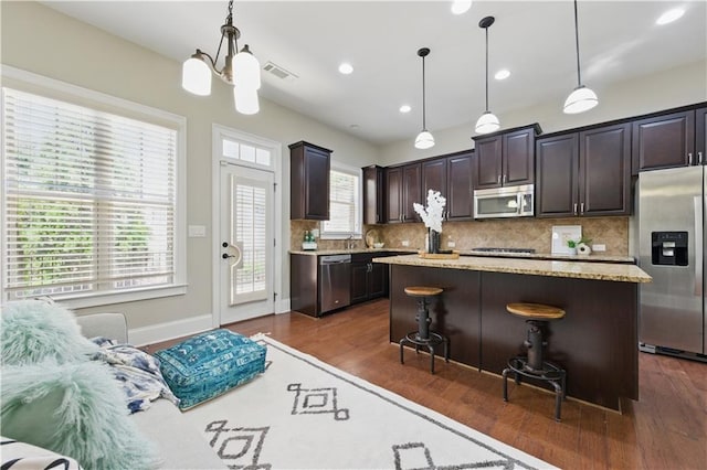2828 Broughton Ln SE, Atlanta, GA 30339 - kitchen featuring stainless steel appliances, dark wood-style floors, tasteful backsplash, dark brown cabinetry, and a kitchen island