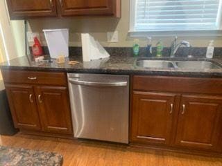 9590 English Ivy Ct, Fortson, GA 31808 - kitchen with brown cabinets, dark countertops, a sink, light wood-style floors, and dishwasher