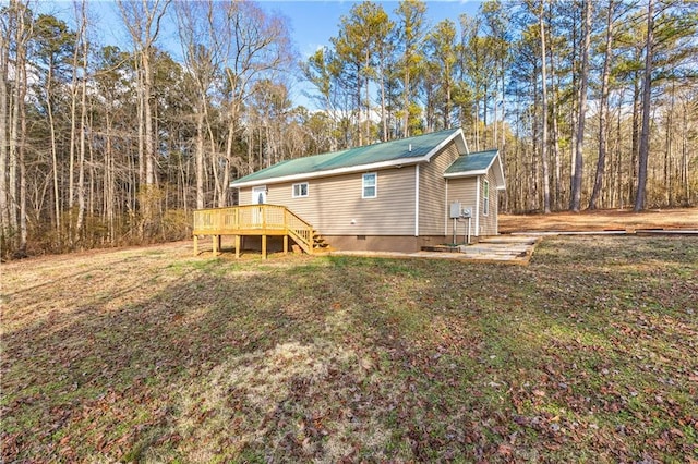 rear view of property featuring a wooden deck and a yard