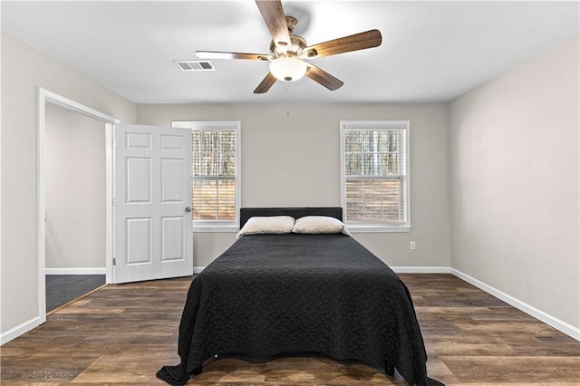 bedroom with dark wood-type flooring, ceiling fan, and multiple windows