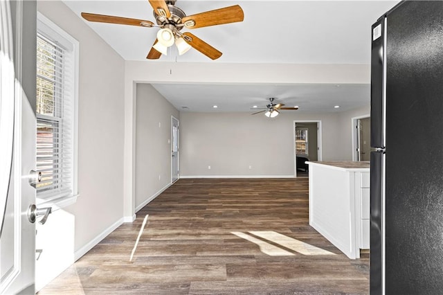 unfurnished living room featuring dark hardwood / wood-style floors and ceiling fan