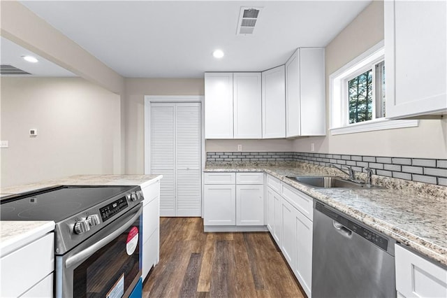 kitchen with stainless steel appliances, white cabinetry, sink, and dark wood-type flooring