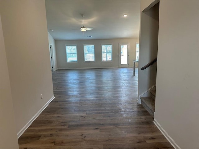 unfurnished living room featuring ceiling fan, a wealth of natural light, and dark hardwood / wood-style floors