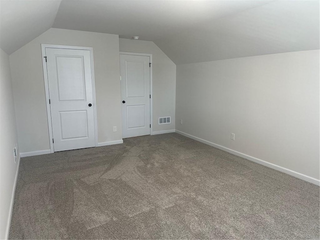 bonus room with lofted ceiling and carpet flooring