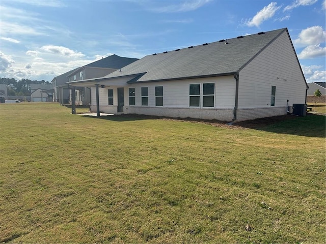 back of property with a patio area, central AC, and a lawn