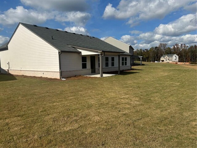 rear view of property featuring a patio and a lawn