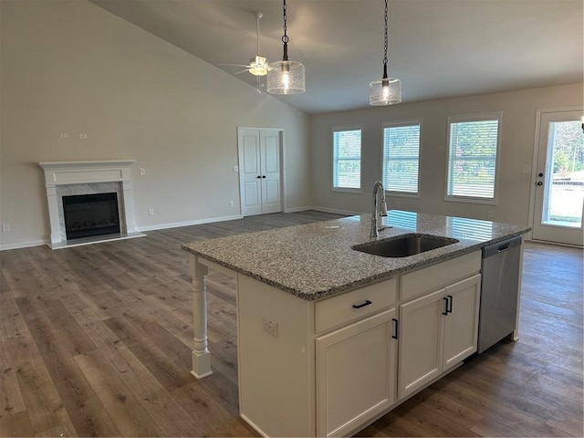 kitchen featuring sink, dishwasher, white cabinetry, lofted ceiling, and a kitchen island with sink