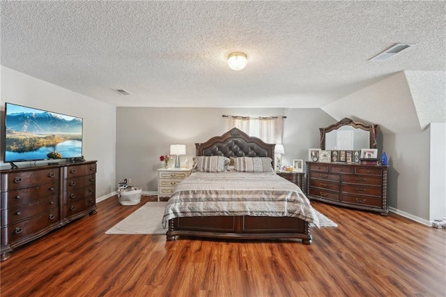 bedroom featuring wood finished floors, a textured ceiling, and baseboards