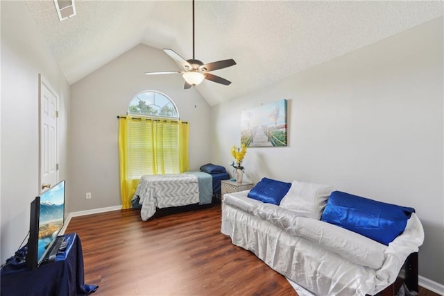 bedroom with wood finished floors, lofted ceiling, a textured ceiling, a ceiling fan, and baseboards