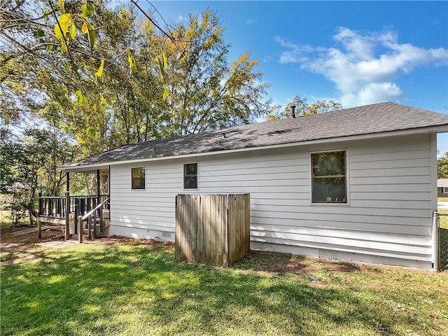 rear view of property with a deck and a lawn