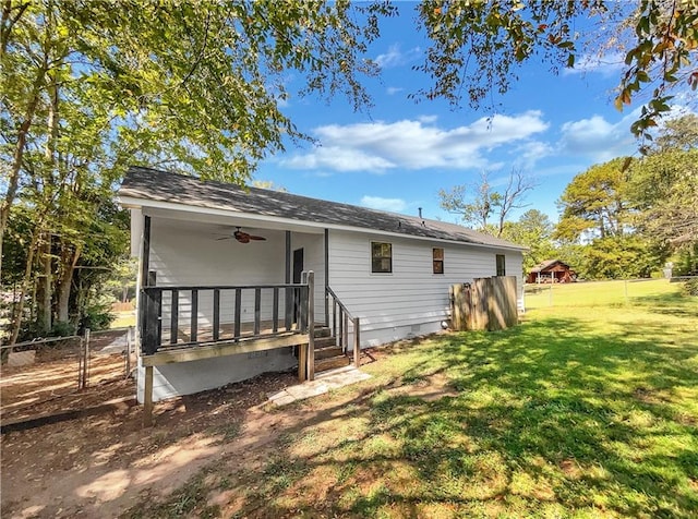 back of house featuring a lawn and ceiling fan