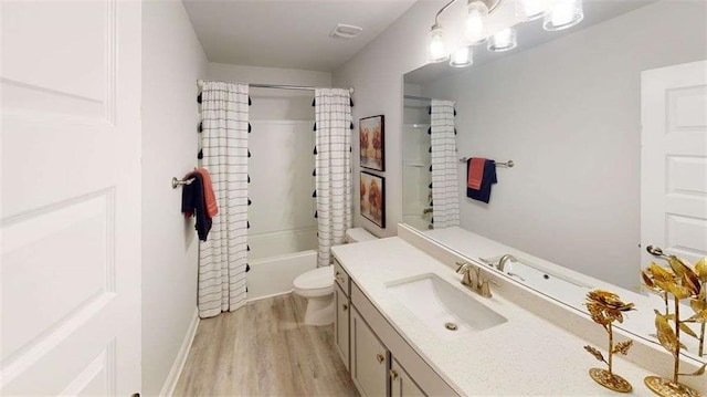 251 Eason St, Bowdon, GA 30108 - bathroom featuring vanity, wood finished floors, toilet, shower / bathtub combination with curtain, and baseboards