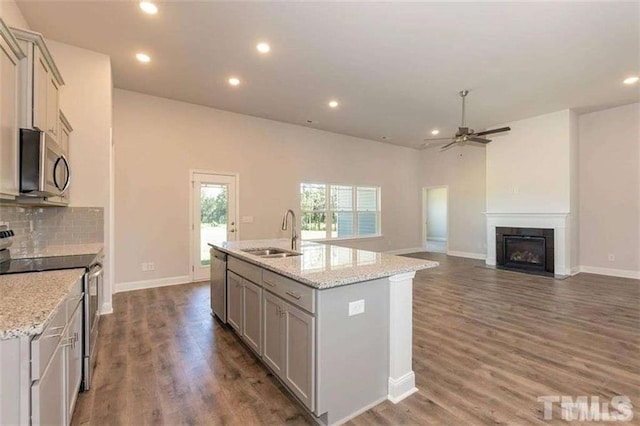 251 Eason St, Bowdon, GA 30108 - kitchen with appliances with stainless steel finishes, a sink, a ceiling fan, a fireplace with flush hearth, and a kitchen island with sink