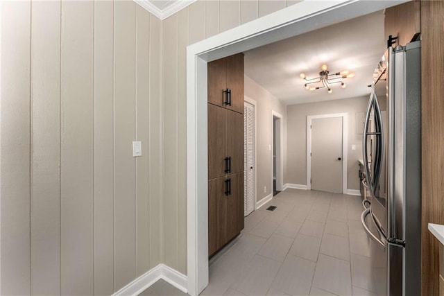 hallway with visible vents, baseboards, and crown molding