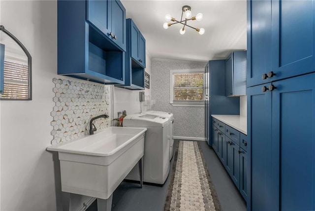 laundry room featuring a sink, baseboards, washer and dryer, cabinet space, and wallpapered walls