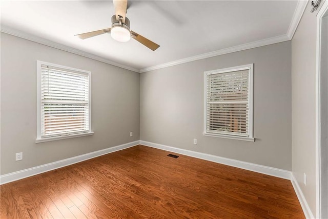 unfurnished room with dark wood-style floors, a ceiling fan, baseboards, and crown molding