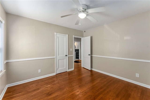 interior space featuring ceiling fan, baseboards, and wood finished floors